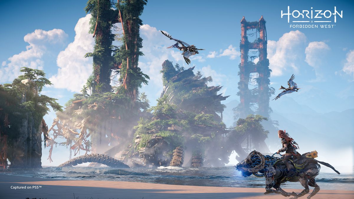 Aloy riding a Charger on the beach past the ruins of the Golden Gate Bridge in Horizon Forbidden West