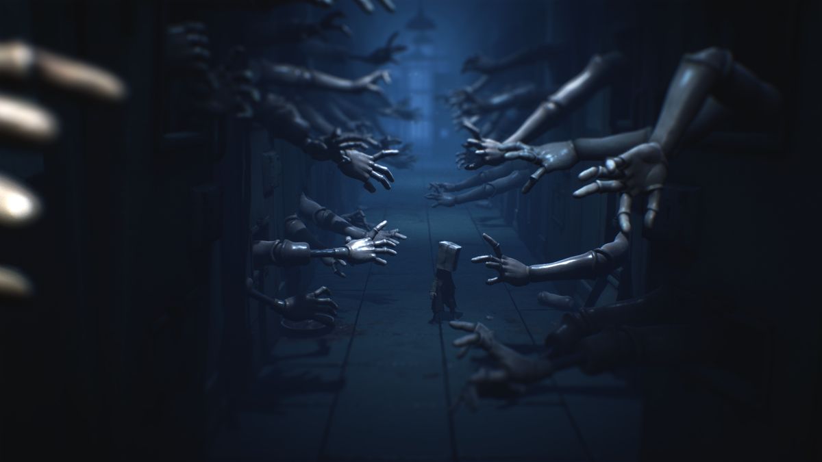 A character walks through a hallway, as dozens of doll arms reach out in a screenshot from Little Nightmares 2