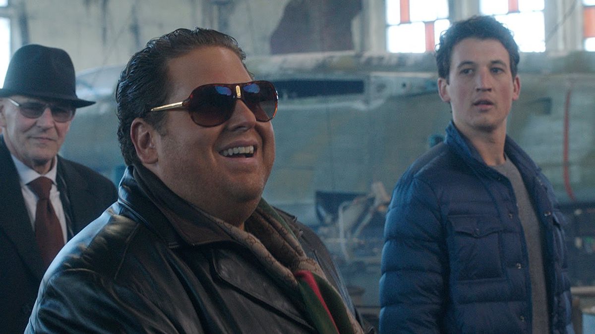 Jonah Hill laughing with big sunglasses on while Miles Teller looks at him awkwardly