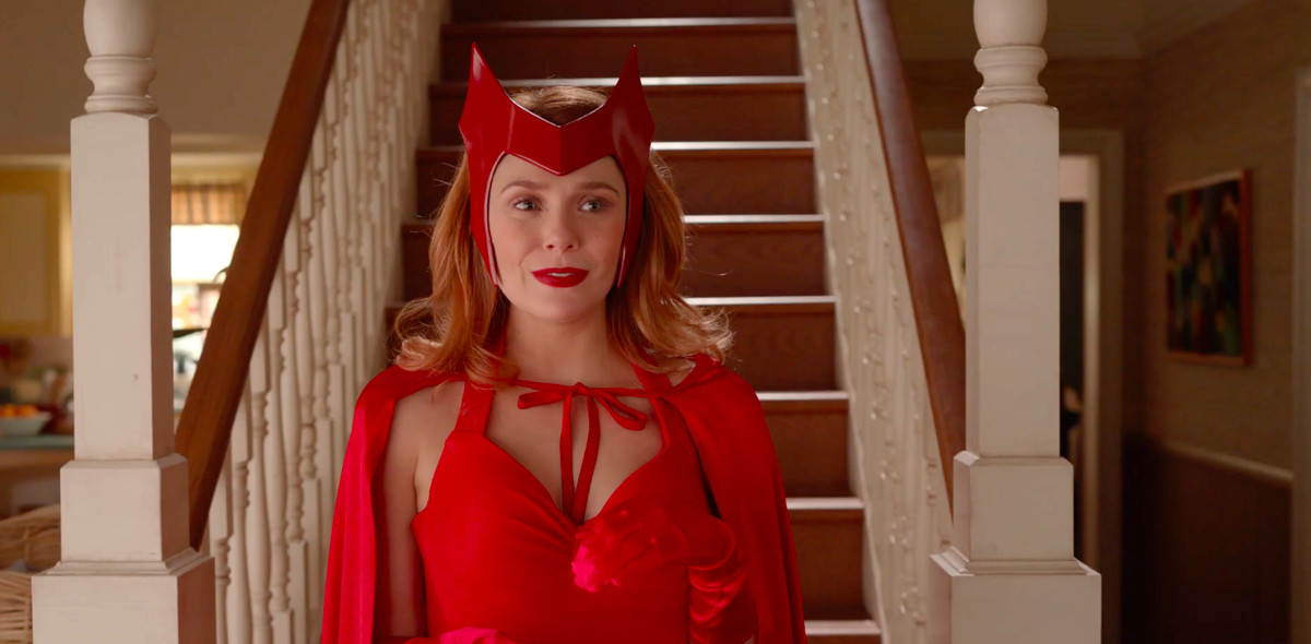 Elizabeth Olsen går ner en trappa som Scarlet Witch i sin klassiska kostym, komplett med handskar, kappa och hårstycke, i ett klipp från teaser för WandaVision.