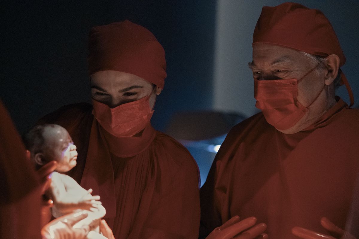 Elliot Mantle (Rachel Weisz) håller ett nyfött barn med en annan läkare (Michael McKean) som tittar över hennes axel