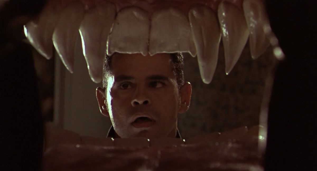 A young Raymond Cruz stares into an open mouth with fangs in From Dusk Till Dawn 2. The camera is from an inside-the-mouth POV.