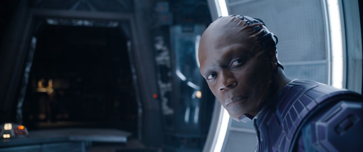 The High Evolutionary (Chukwudi Iwuji), en skallig man med ett inympat ansikte och högteknologisk blå rustning, stirrar utanför skärmen i Guardians of the Galaxy Vol.  3
