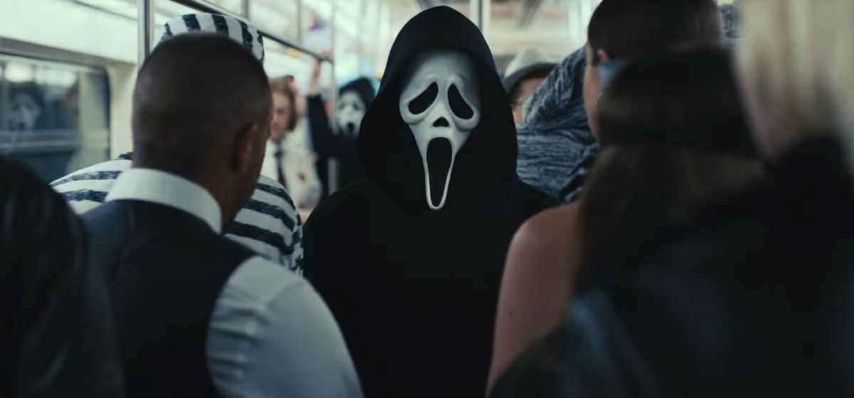En person som bär en Ghostface-mask står på en fullsatt tunnelbanevagn i New York City i en stillbild från Scream VI.