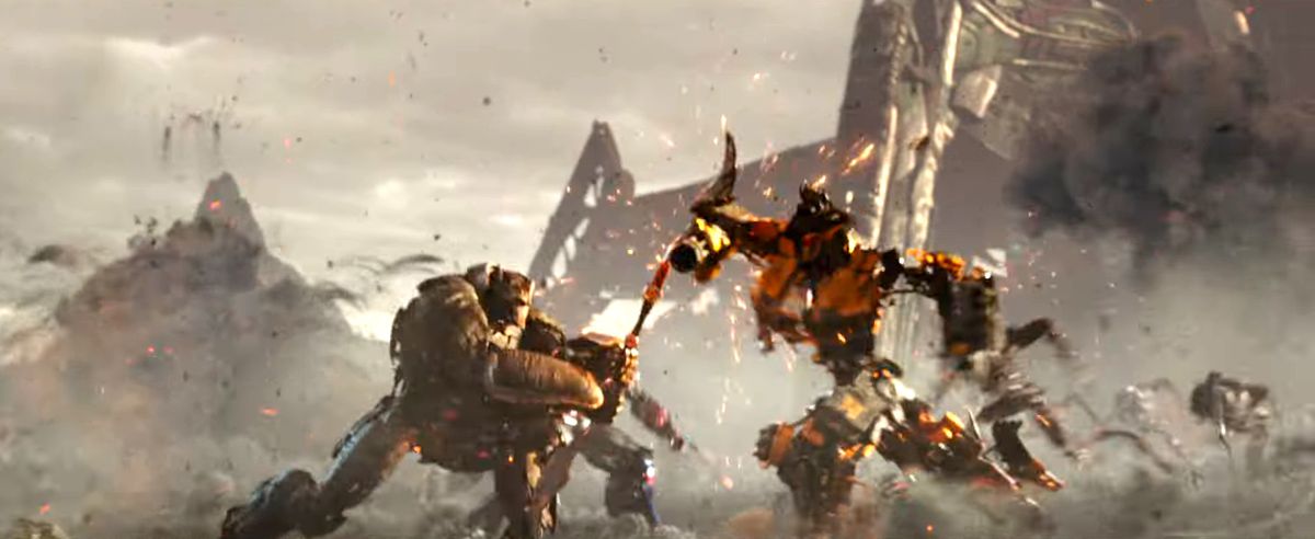 Optimus Primal i robotform slåss mot en gul Transformer med ett spjut i Transformers: Rise of the Beasts