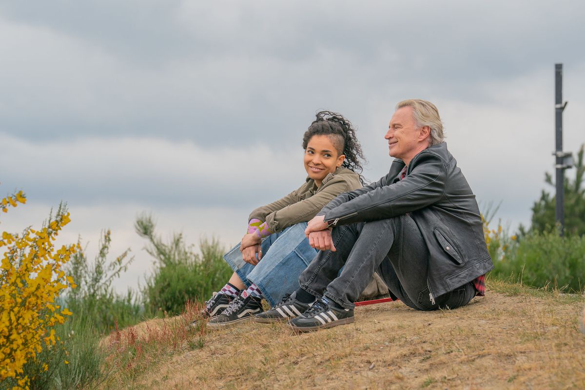 Gaz (Robert Carlyle) och hans tonårsdotter Destiny (Talitha Wing) sitter på en kulle täckt med dött gräs under en mulen himmel och ler mot varandra i FX:s spinoff-tv-program The Full Monty