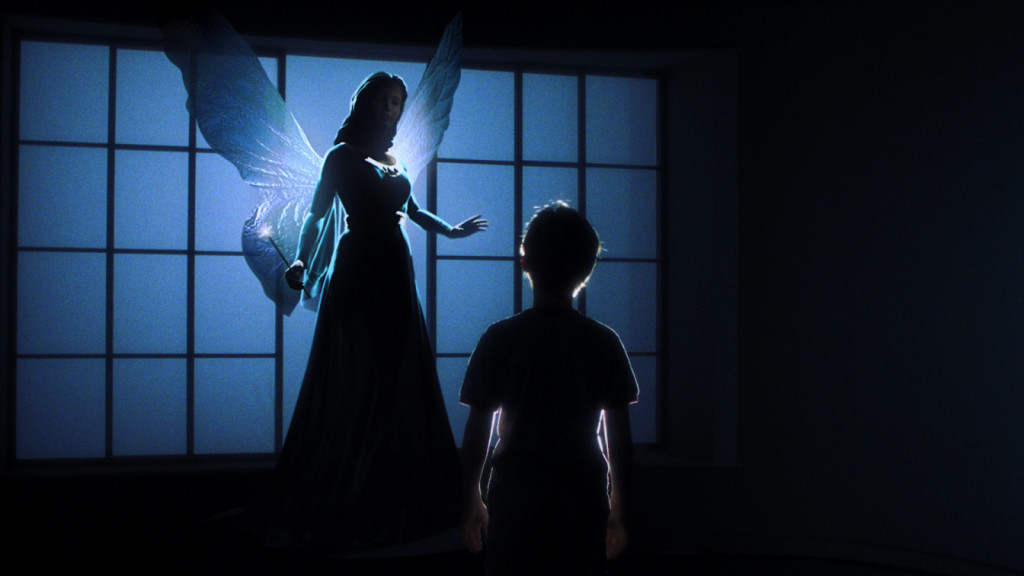 A young stars up at a woman in a majestic blue dress with fairy wings holding a wand in a darkened room.