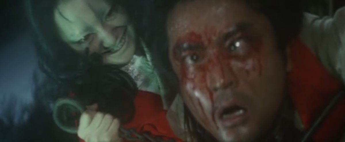 A woman with a sinister smile stabs a bloody man in the neck in Curse of the Dog God.