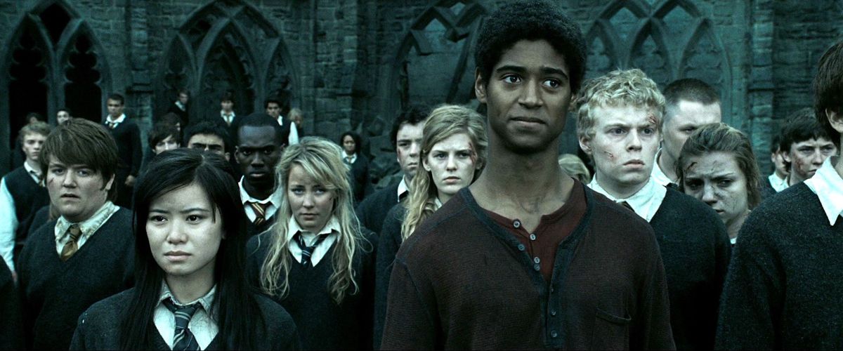 Cho Chang (Katie Leung), Dean Thomas (Alfred Enoch) och en skara andra Hogwarts-elever står misshandlade och blodiga framför skolan i Harry Potter and the Deathly Hallows: Part 2.