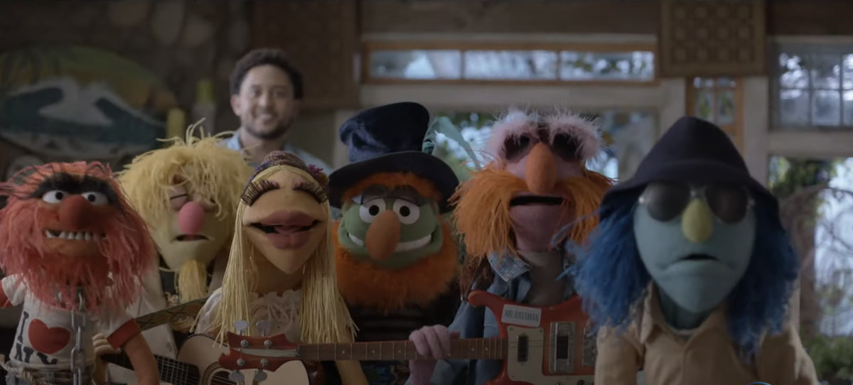 The Electric Mayhem Band stands and looks straight at the camera