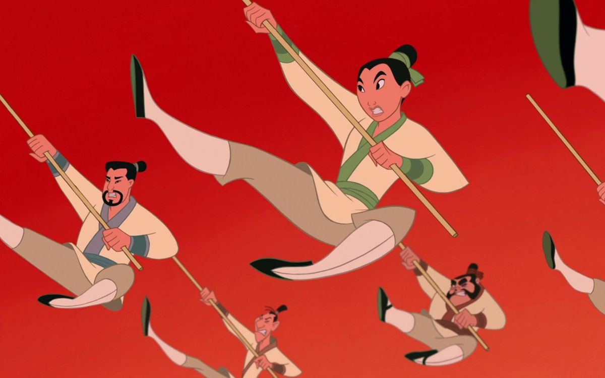 Mulan in her army uniform does a high kick with a staff strike, in unison with other members of her training unit, during the “Be A Man” number in the Disney animated movie Mulan