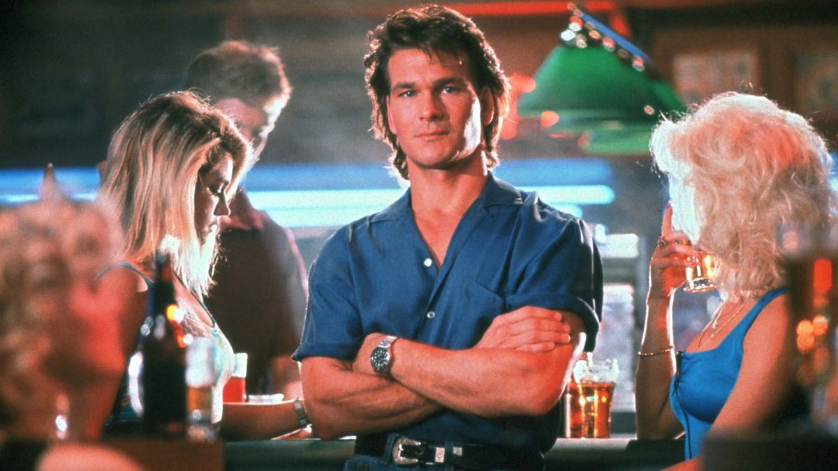 Patrick Swayze crosses his arms at the bar in Road House