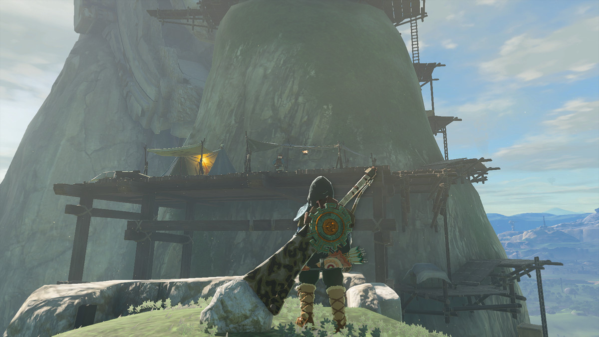 Link tittar på ett undersökningsläger i The Legend of Zelda: Tears of the Kingdom.  Det finns byggnadsställningar inbyggda i en stenig sluttning.
