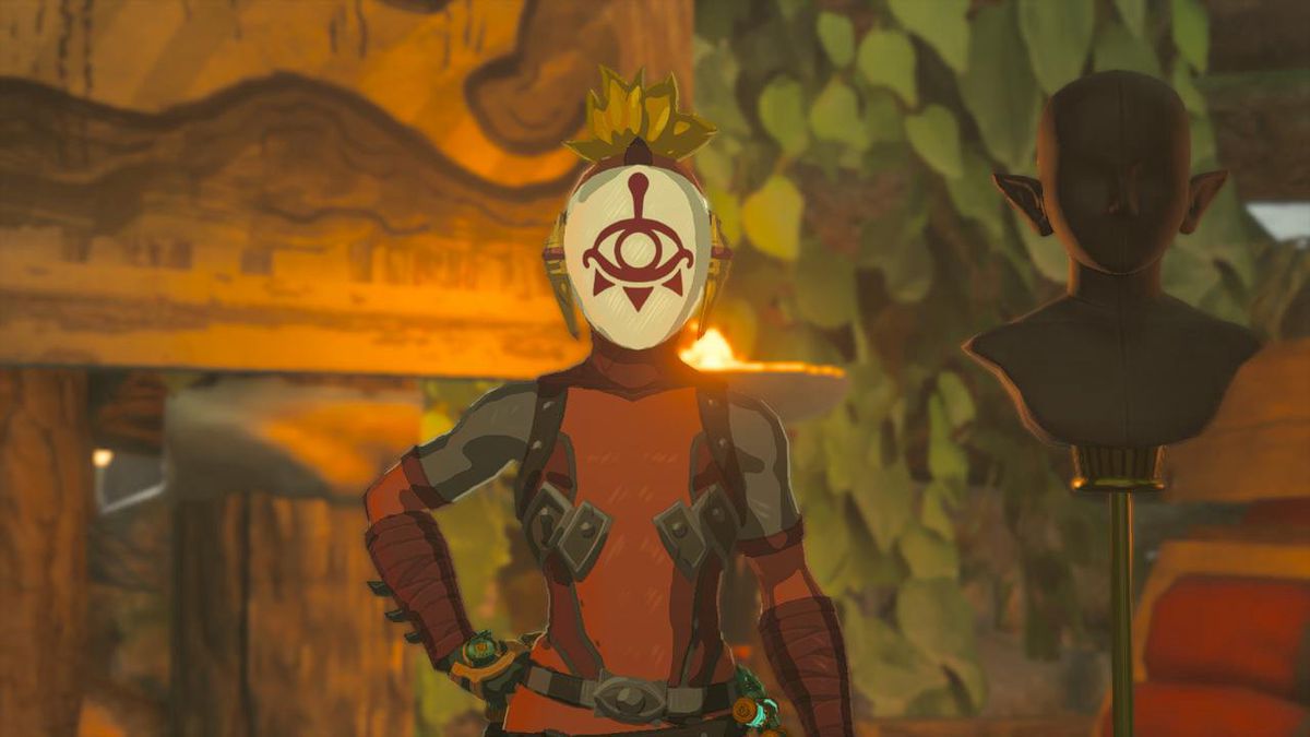 Link poses alongside a head bust wearing the Yiga Armor set in Zelda: Tears of the Kingdom