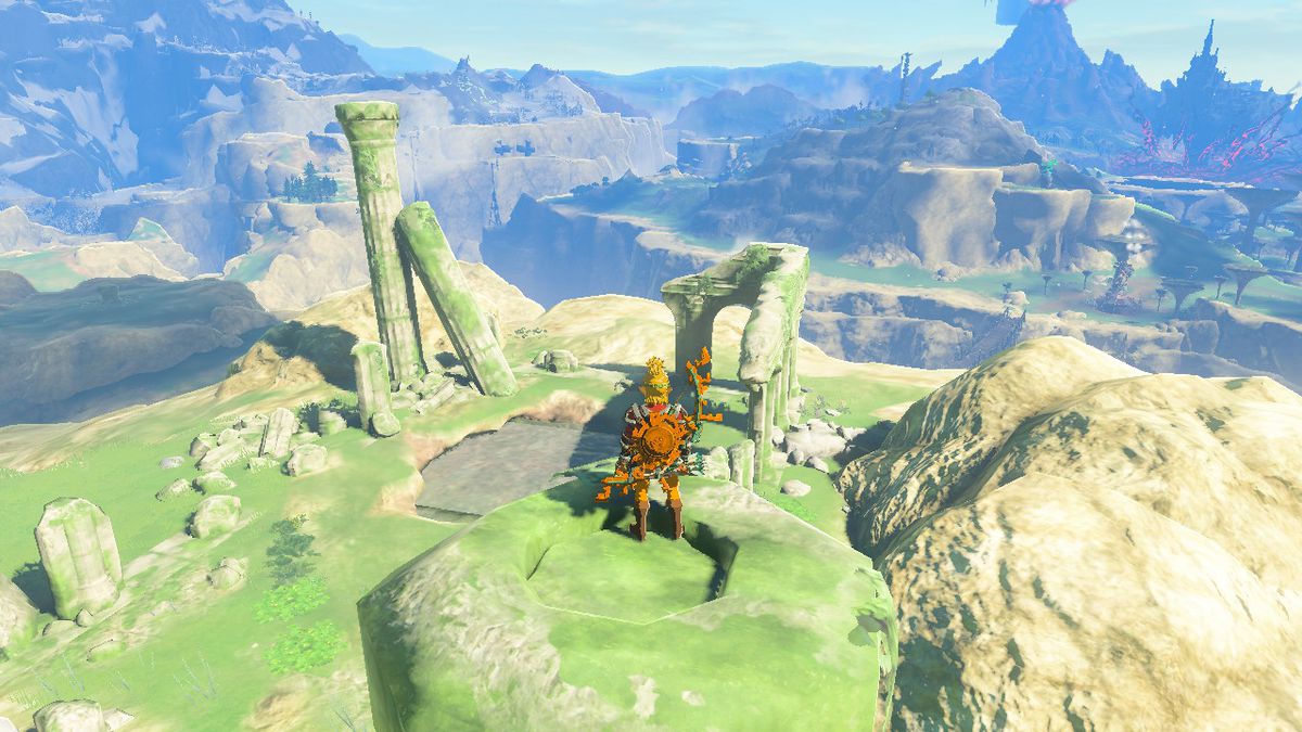 Link står på toppen av en gräsbevuxen pelare medan han letar efter Awakening Armor i Zelda Tears of the Kingdom.
