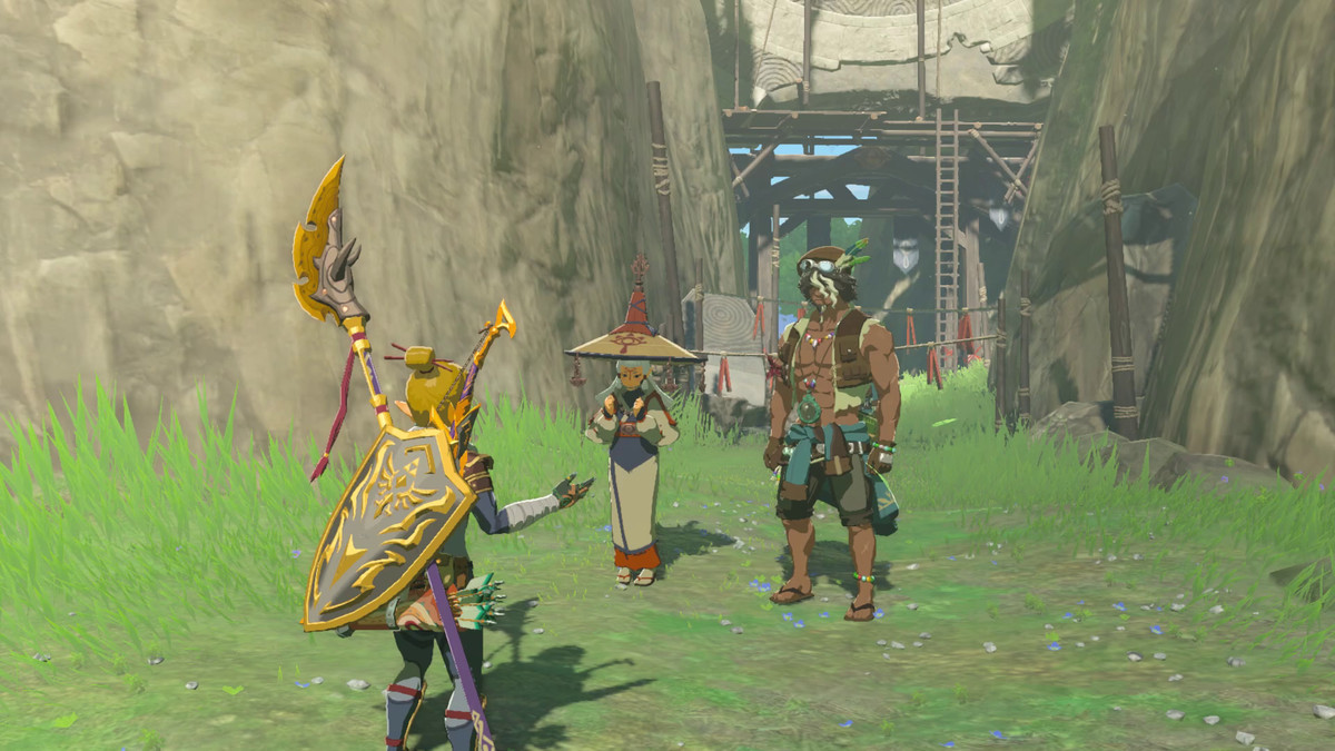 Link står och pratar med Paya och Tauro, två personer som står vid Ringruinerna i Rikets tårar.  Paya står i dräkter och en stor hatt, medan Tauro har magen ute.