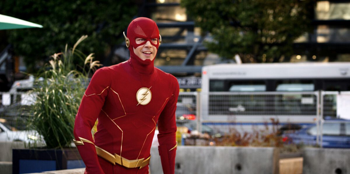 Grant Gustin som blixten i kostym som ler när han är på väg att bryta sig in i en spurt i The CW:s The Flash
