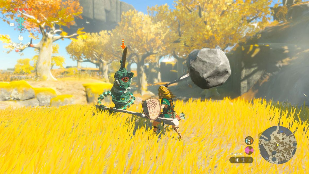 En bild av Link i The Legend of Zelda: Tears of the Kingdom svingar en pinne som smälts samman med en sten.