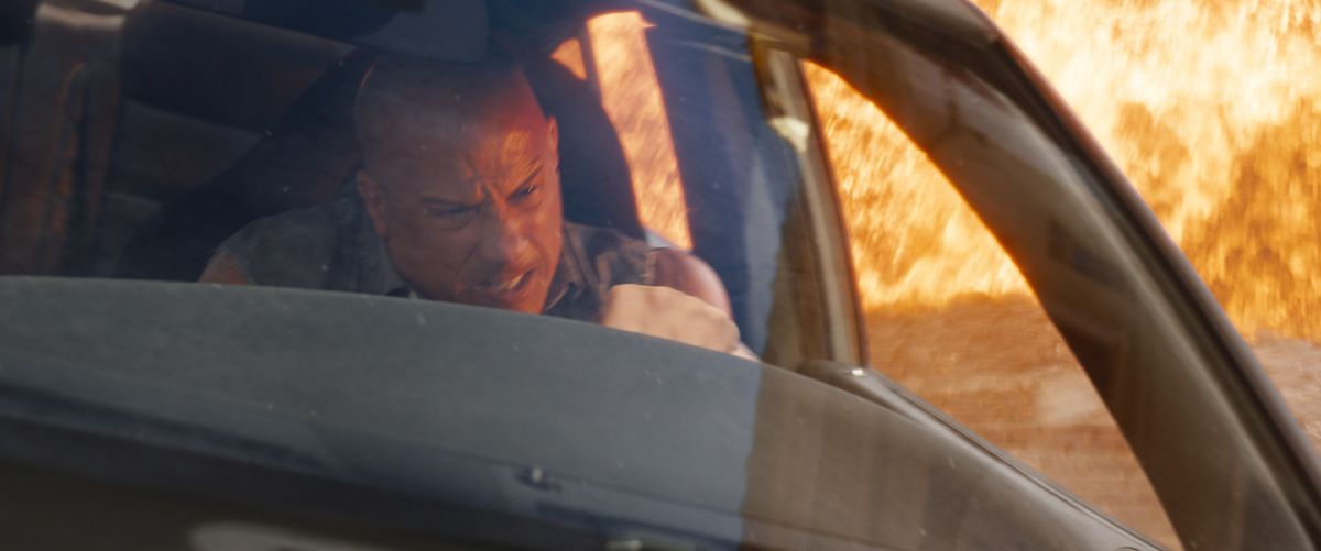 Dominic Toretto (Vin Diesel) grimaserar när han försöker springa ifrån en enorm explosion i sin bil i Fast X