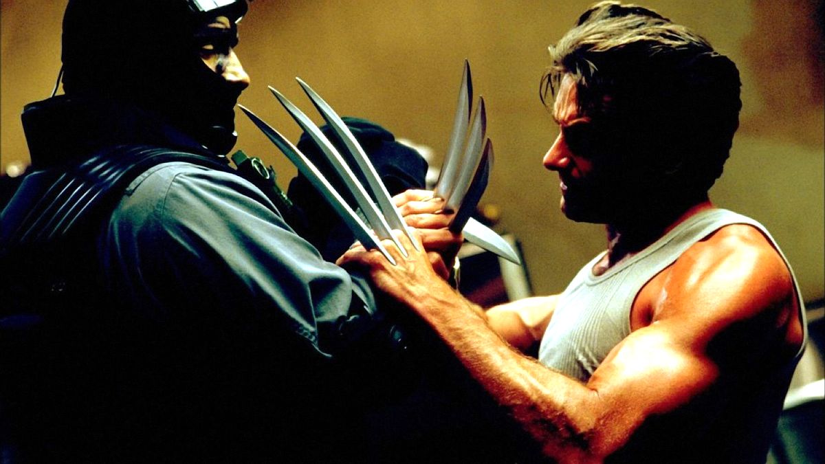 Hugh Jackman som Wolverine i X2: X-Men United sätter sina adamantium-klor i en svartmaskad mooks ansikte 