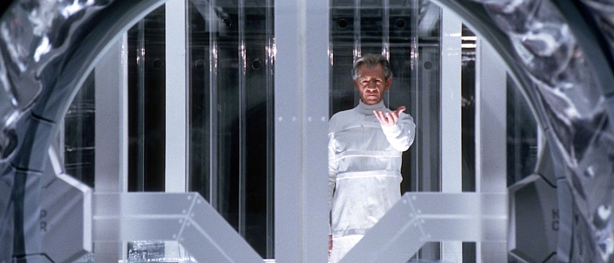 Magneto (Ian McKellan), helt vitt, står i sitt glasfängelse i X2: X-Men United och höjer handen med handflatan uppåt när han börjar sin flykt