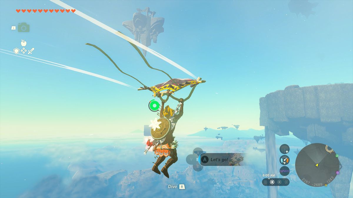 Link paraglides toward the island with a waterfall on one of its sides in Zelda: Tears of the Kingdom