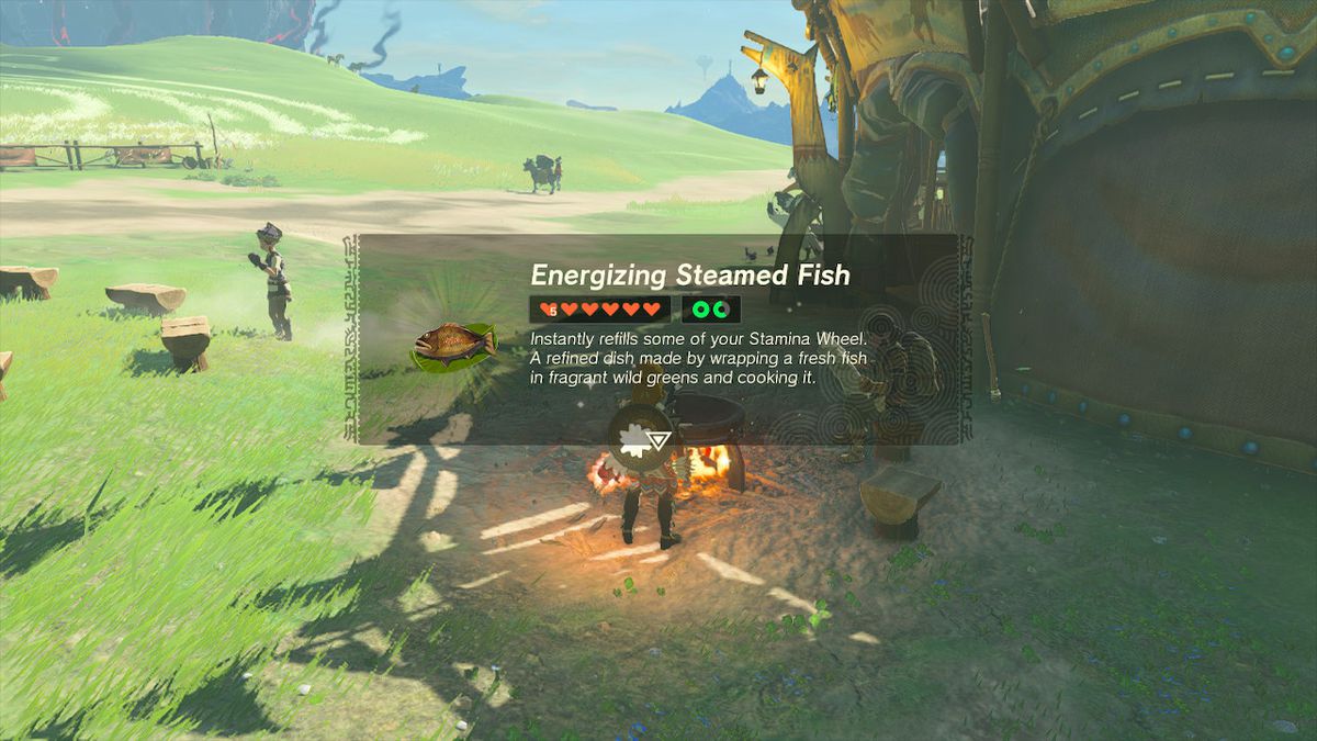 Link cooks an Energizing Steamed Fish next to a stable in Zelda: Tears of the Kingdom