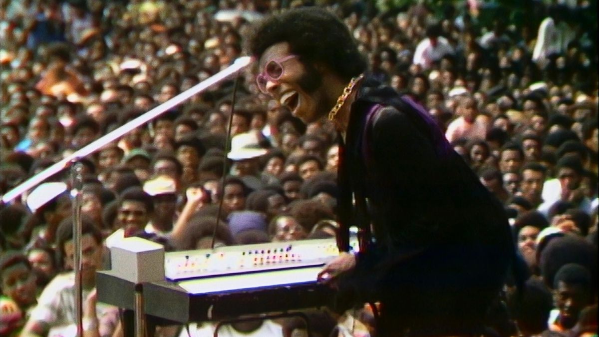 Sly Stone i framträdande med en stor publik i bakgrunden i Summer of Soul