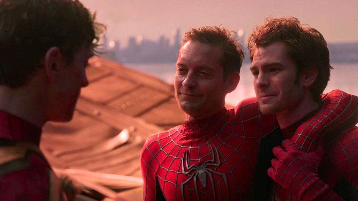 Spider-Mans Tobey Maguire and Andrew Garfield, both looking battered and dirty, support each other and smile at fellow Spider-Man Tom Holland in Spider-Man: No Way Home