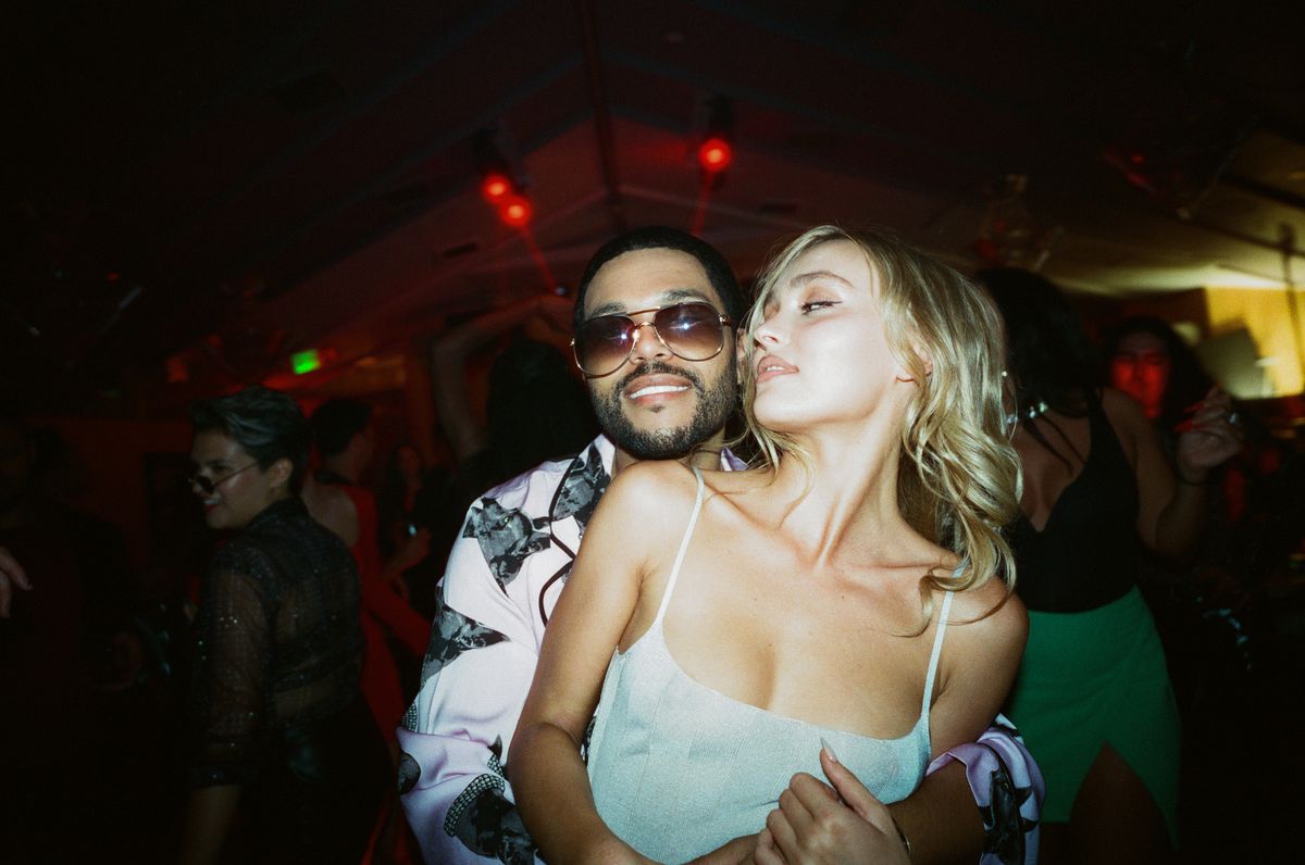 Tedros (Abel “The Weeknd” Tesfaye) kramar Jocelyn (Lily Rose-Depp) bakifrån på ett foto som är tänkt att se ut som om det togs med en blixtkamera på en nattklubb, från HBO-serien The Idol.