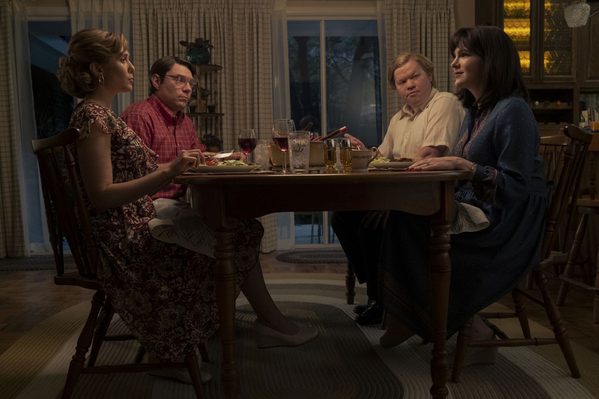 Candy (Elizabeth Olsen) and Betty (Lily Rabe) sit at dinner with their husbands (Patrick Fugit and Jesse Plemons) in a still from Love & Death