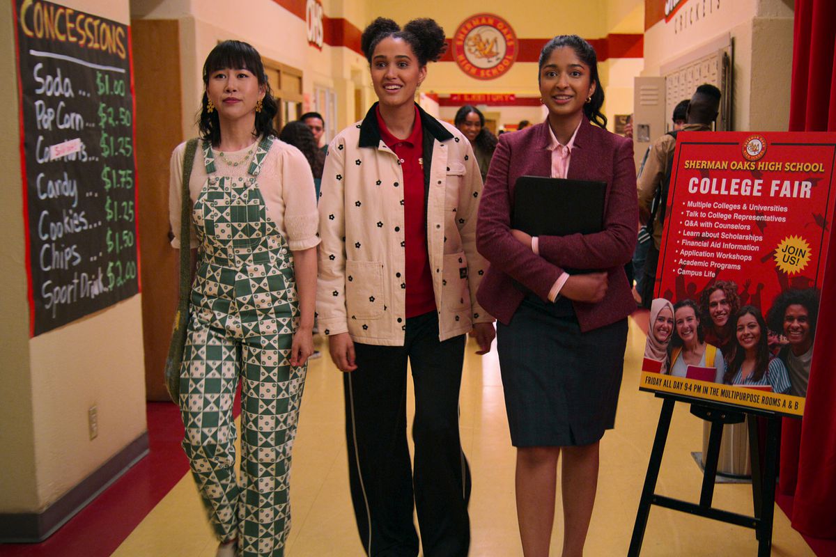 Eleanor, Fabiola och Devi i gymnasiets korridor, klädde ut sig för en högskolemässa. 