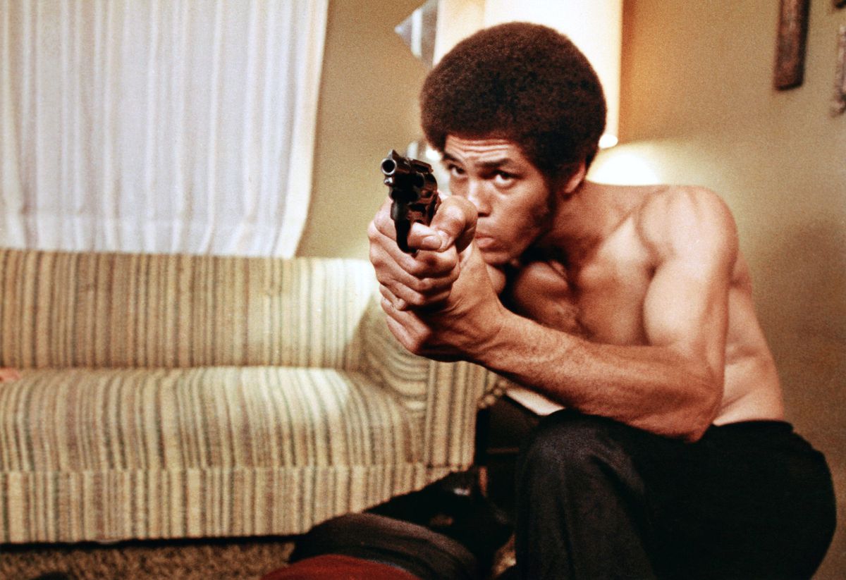 A shirtless Jim Kelly holds a revolver towards the camera in Black Samurai.