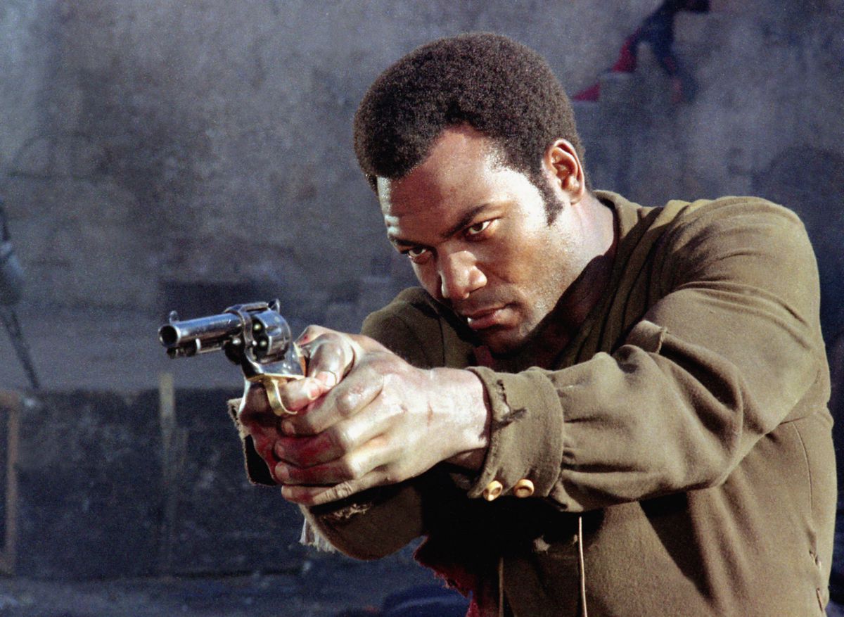 Jim Brown holds a revolver in El Condor