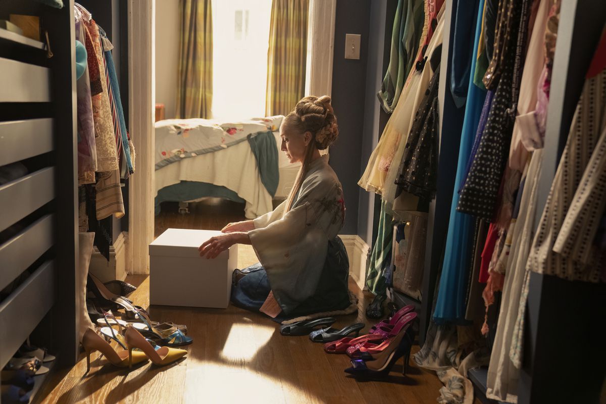 Carrie (Sarah Jessica Parker) sitter i sin garderob och öppnar en låda i en stillbild från And Just Like That... säsong 2