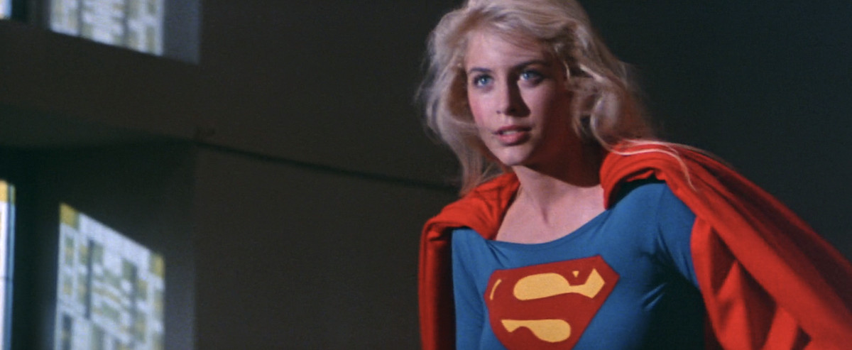 Supergirl (Helen Slater), in the iconic costume, stands up with her blond hair whipping around her face in the climactic confrontation in 1984’s live-action Supergirl movie.