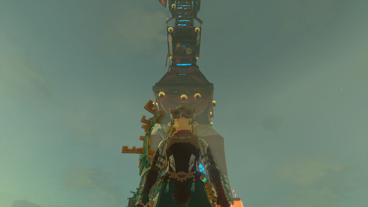 Link stands next to a Skyview Tower in Zelda: Tears of the Kingdom