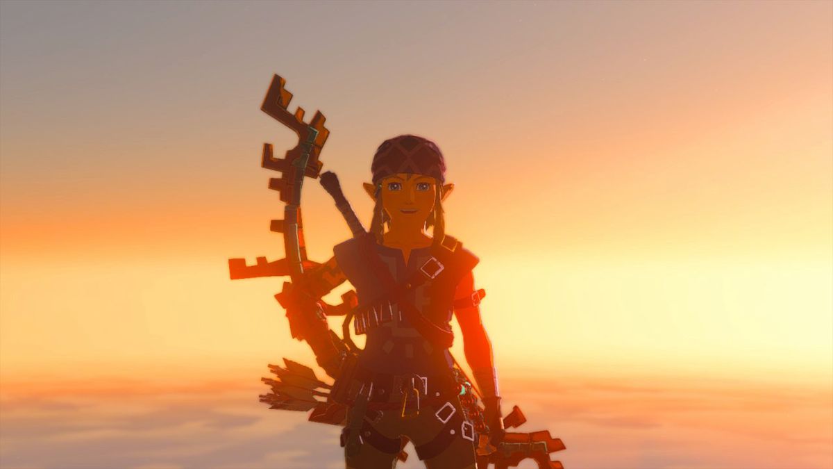 Link smiles while wearing the Climbing Armor set with the sunset behind him in Zelda: Tears of the Kingdom