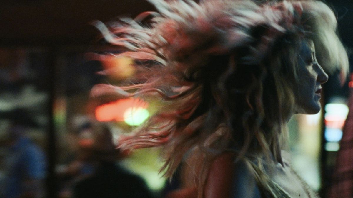 Andrea Riseborough som Leslie Rowland, går över en livlig stadsgata med håret som blåser vilt i vinden i To Leslie.