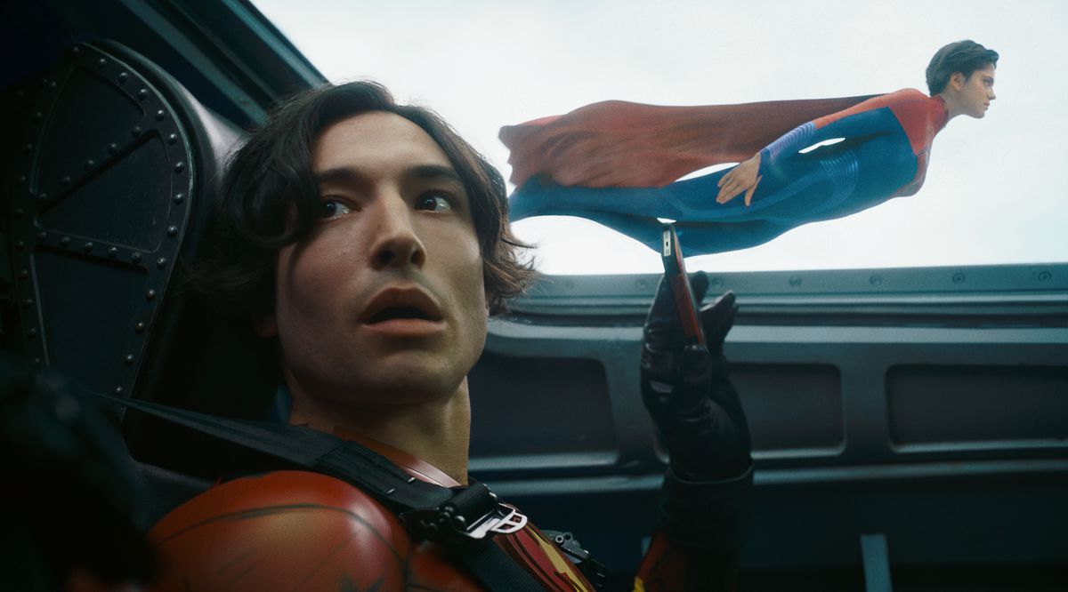 Ezra Miller som Young Barry ser fånig ut när han tar mobilvideo av Sasha Calles Supergirl som flyger förbi planet han är i i The Flash.