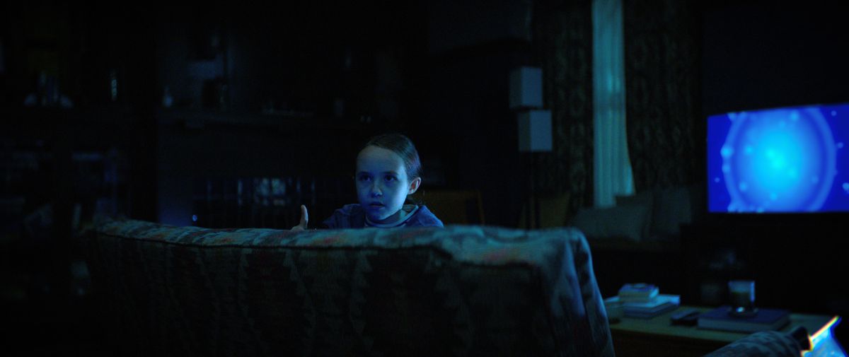 Sawyer (Vivien Lyra Blair) kikar över soffan medan den blå TV:n lyser bakom henne i The Boogeyman