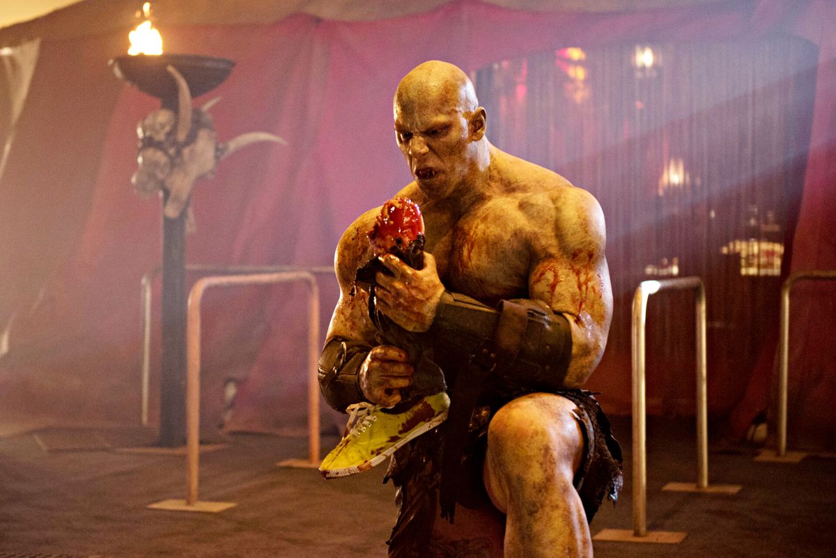 Martyn Ford som The Ogre, äter ett avhugget ben, i Syfy-serien Blood Drive