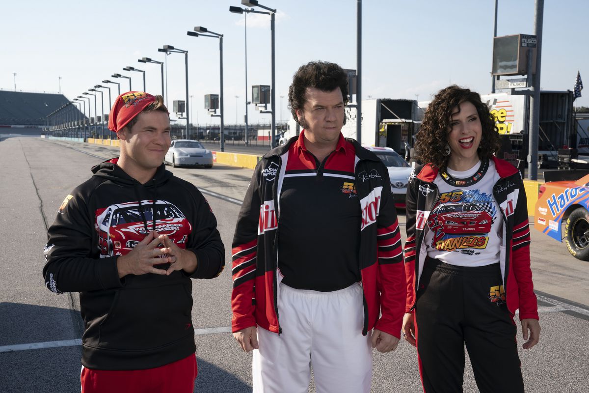 Gemstone-barnen (Adam Devine, Danny McBride och Edi Patterson) står i racerkläder på en racerbana