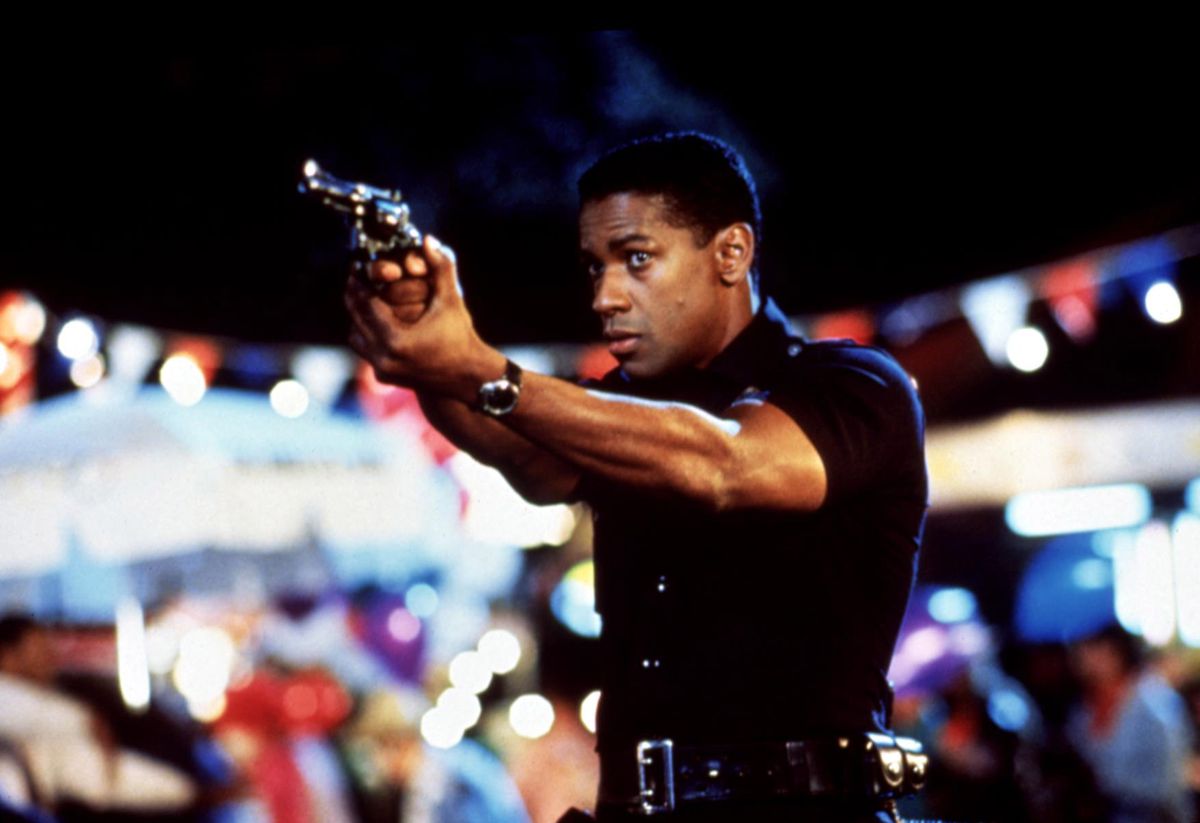 A young Denzel Washington takes aim with his revolver while wearing a police uniform in Ricochet.