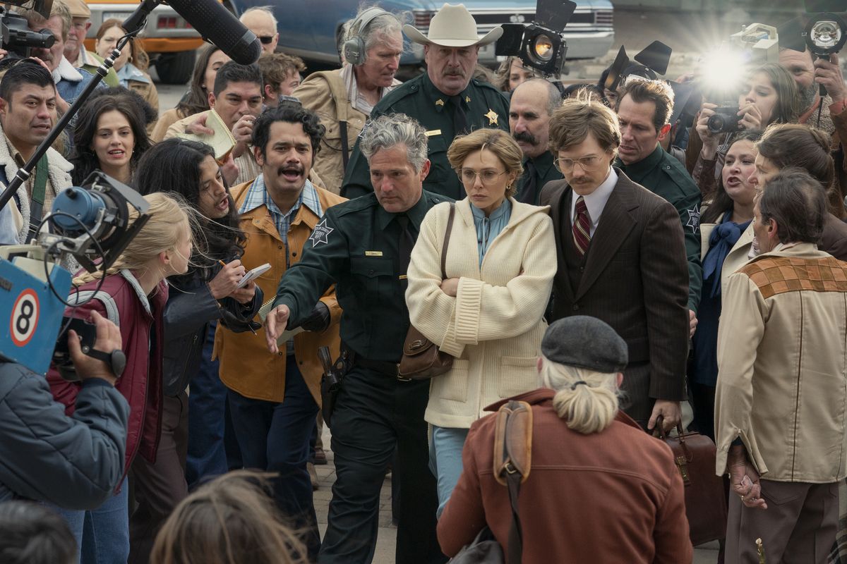 Candy (Elizabeth Olsen) walking into the courthouse while mobbed by press in a still from Love & Death