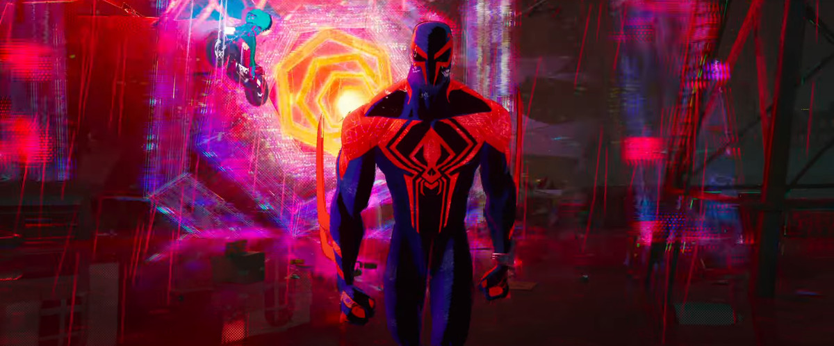 Spider-Man 2099 går mot kameran med ett färgstarkt maskhål av rött, rosa, gult och blått virvlar runt bakom sig i Spider-Man: Across the Spider-Verse
