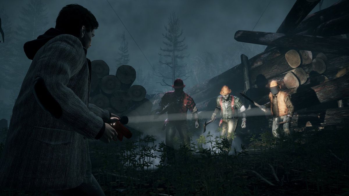 Alan Wake lyser med en ficklampa mot en grupp yxsvingande angripare i Alan Wake: Remastered.