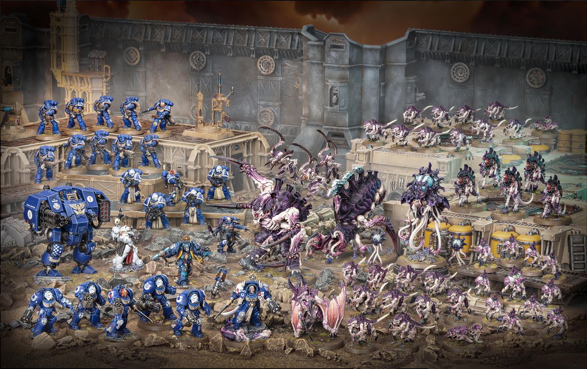 Den kompletta Warhammer 40 000: Leviathan-boxen innehåller 72 miniatyrer, som visas här på plastterräng som inte följer med setet.  Space Marines är blå och tyrannider är lila och rosa.  Scenen utspelar sig längs en stor kant.