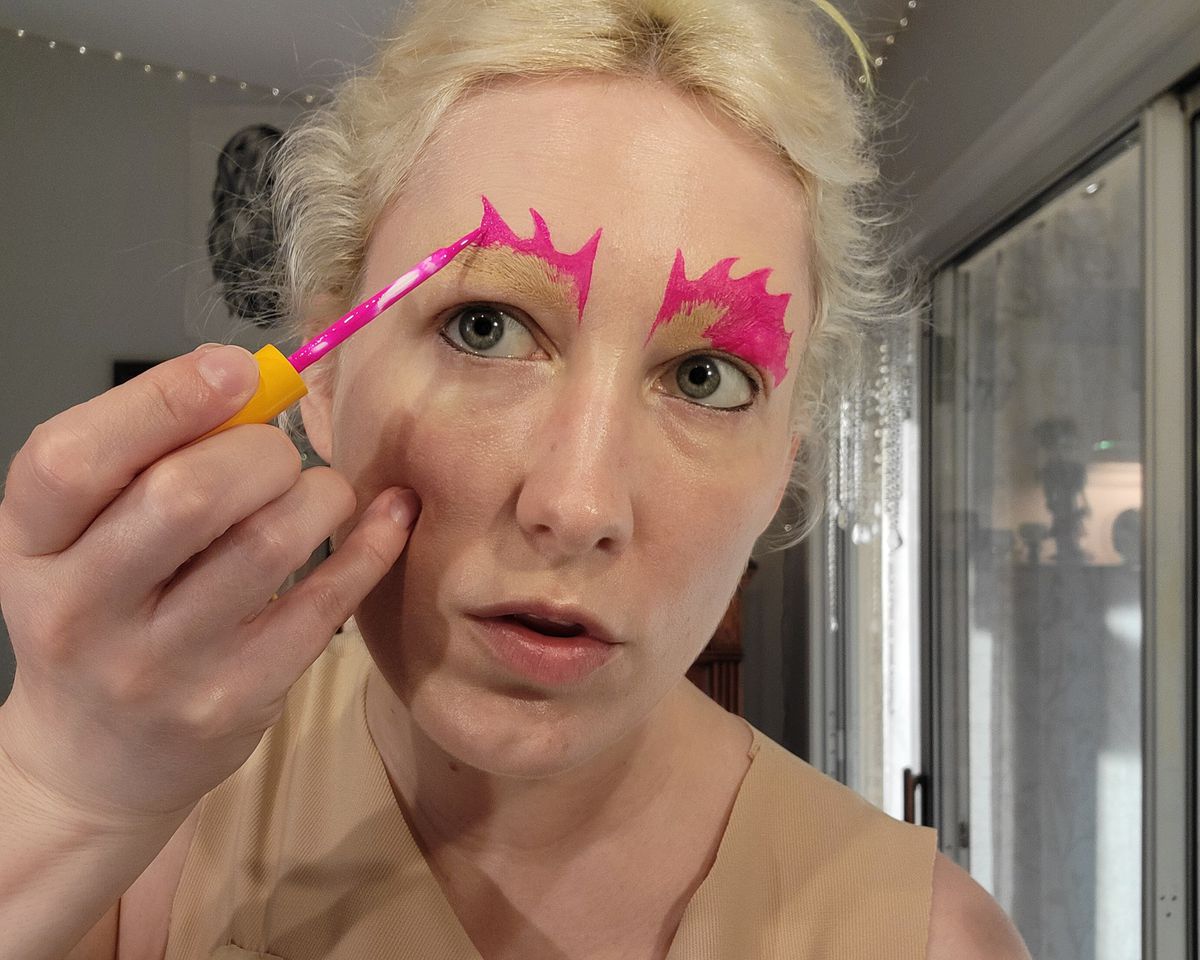 The author drawing a pink spiky pattern above her eyebrow.