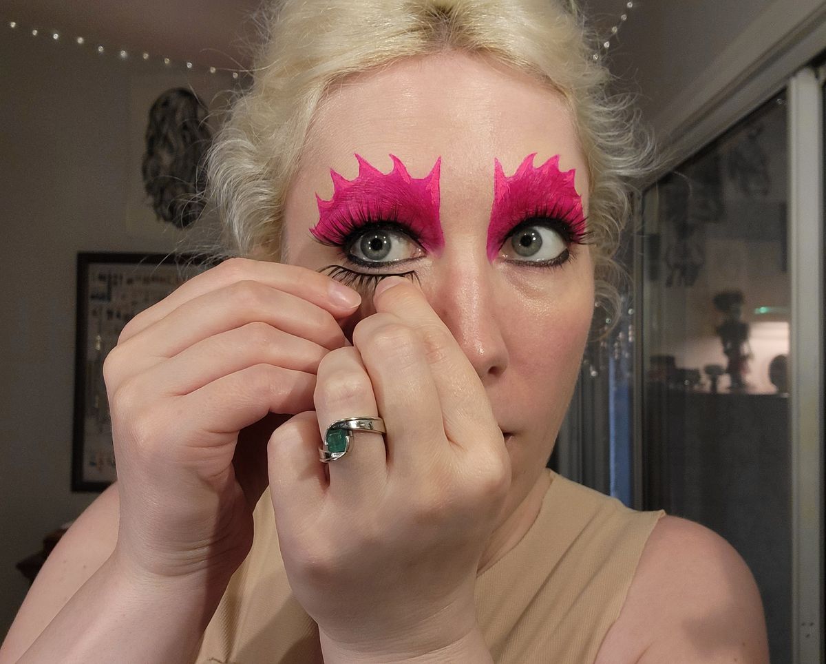 The author putting fake lashes on her bottom lashline.